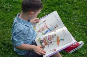 boy learning outside by reading